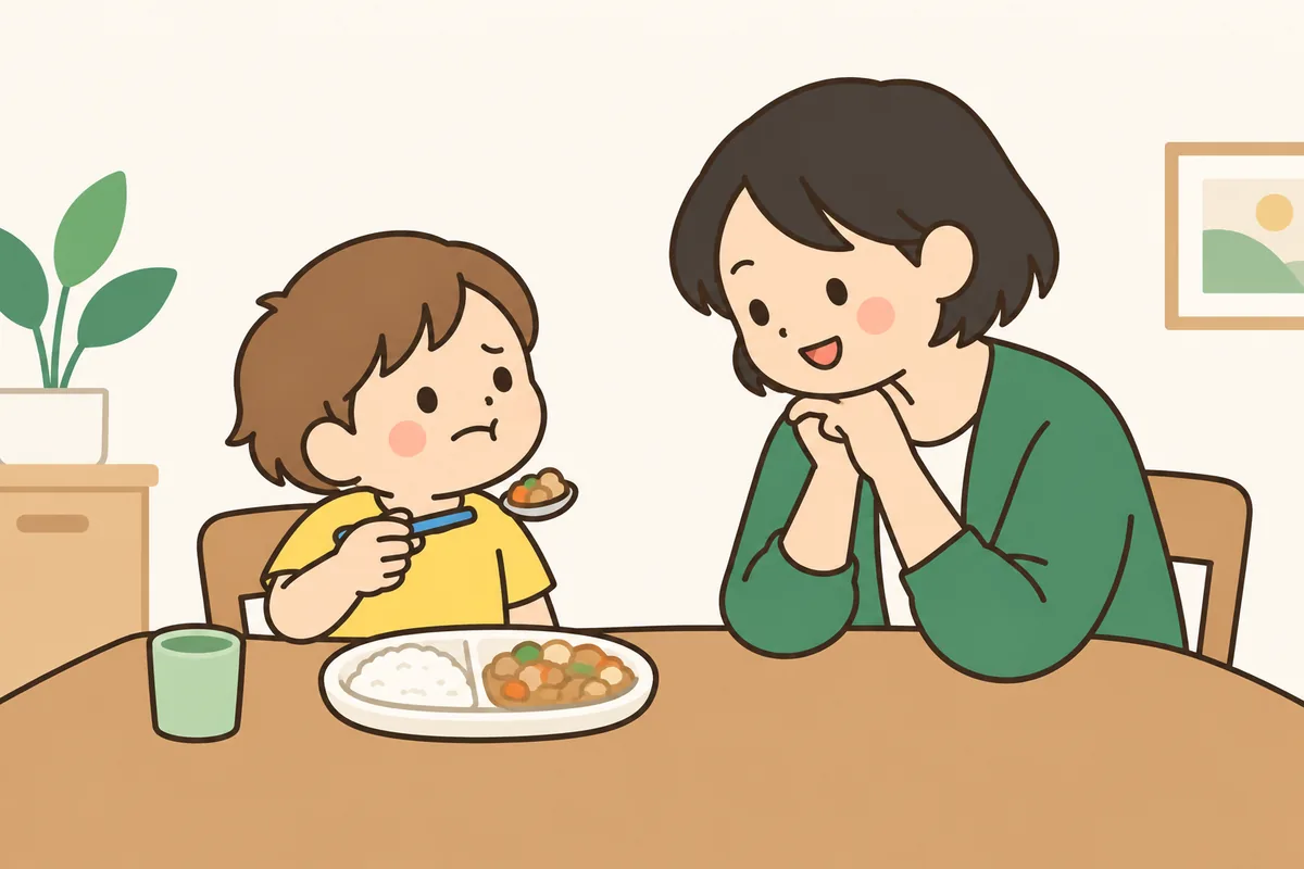 食卓で、子どもがスプーンの上の食べ物を見て顔をしかめている
