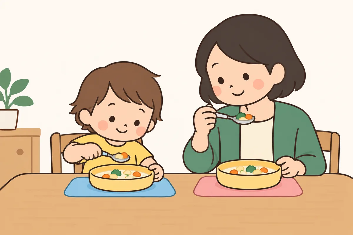 スプーンですくおうとする子どもと、隣でスプーンを使って見せる大人。