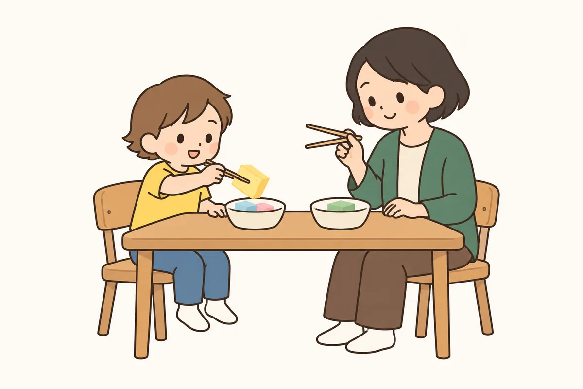 箸でスポンジをはさみ、別の器へ移して遊ぶ子どもと大人。