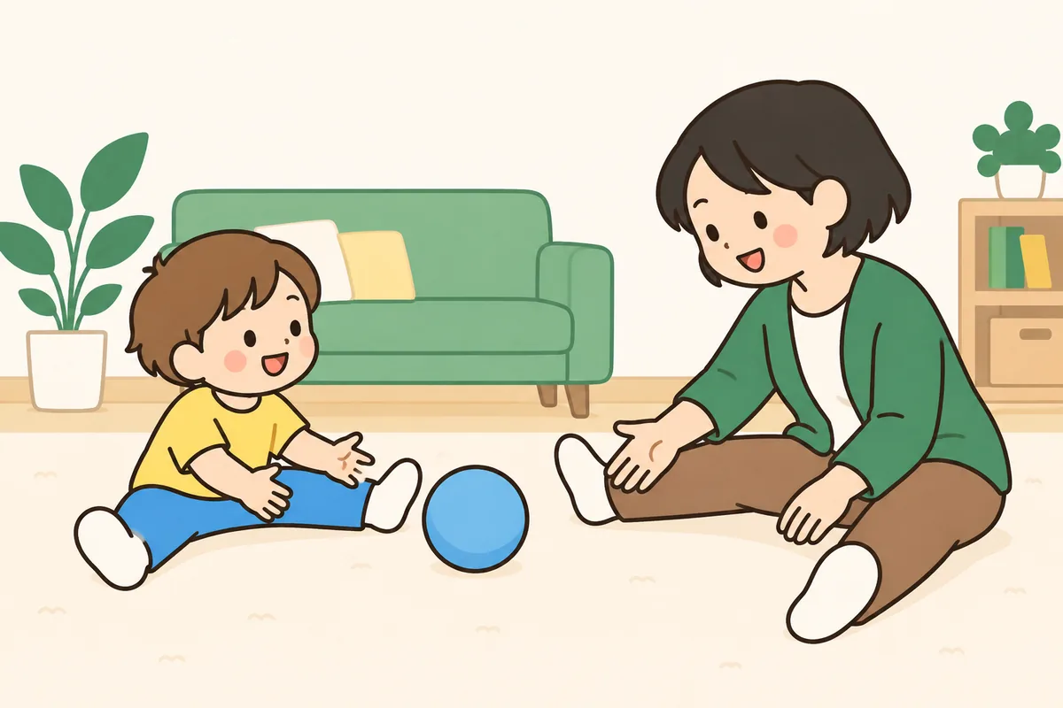 床で、子どもと大人が交代でボールを転がし合っている
