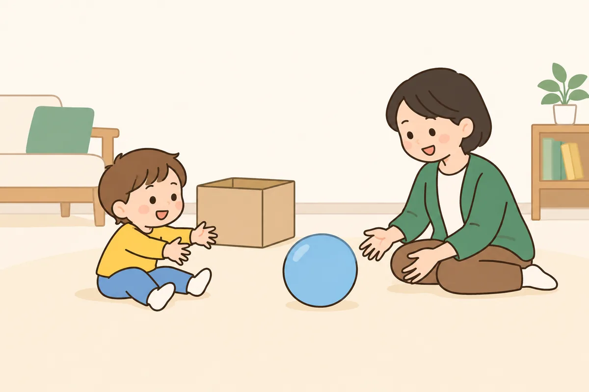 子どもと大人が、床に座ってやわらかいボールを転がし合っている