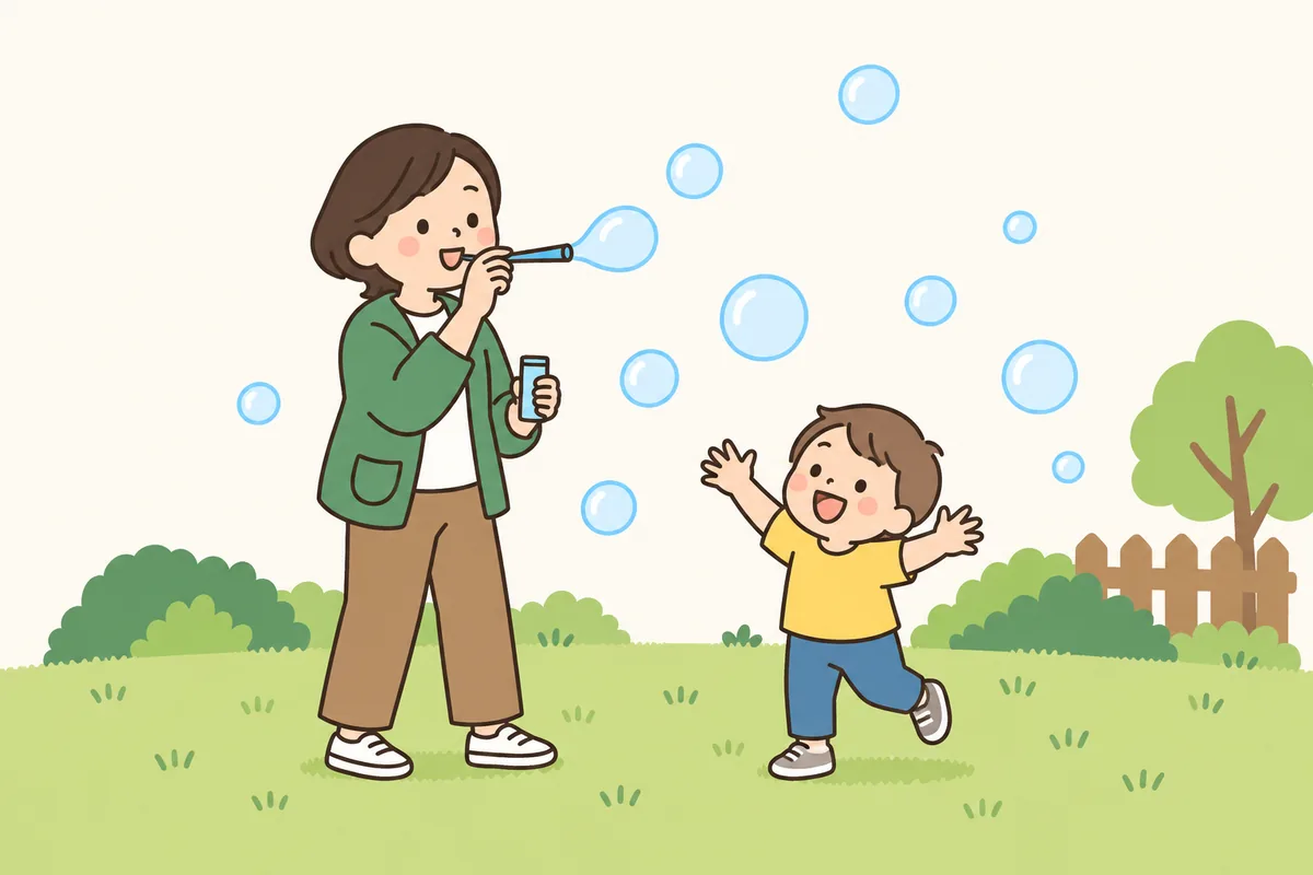 大人が吹いたシャボン玉に、子どもが手を伸ばしている